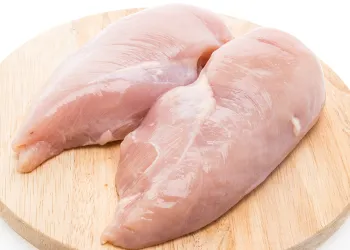 Chicken breast on wooden chopping board