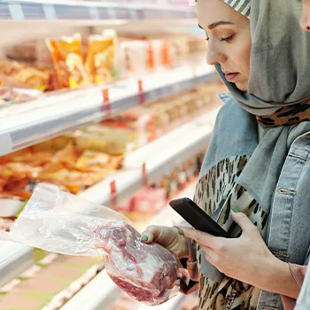 A woman choosing a meat to buy in a supermarket