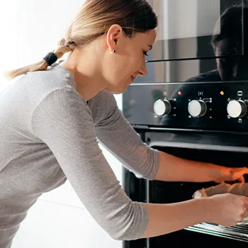 Woman putting dish in oven to cook