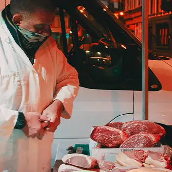 Butcher standing behind displayed meat