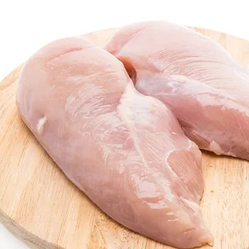 raw chicken breasts on wooden board