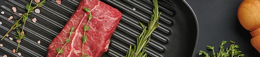 Top blade steak on grill pan with rosemary