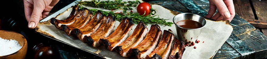 A woman serving a smoked pork ribs on a plate