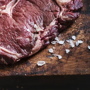 Dry aged meat trimming on wooden cutting board