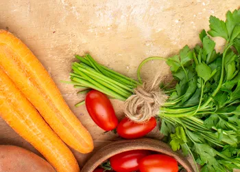 Carrots and greens on top of kitchen table