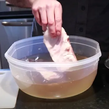A man doing the wet cure method for the pork belly