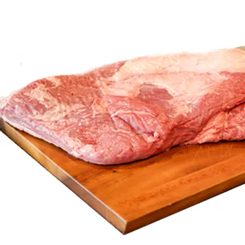 Raw Franklin brisket on a wooden cutting board plain background