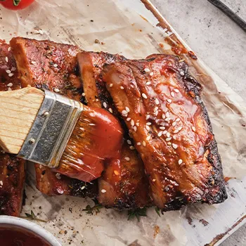 Basting ribs using a brush