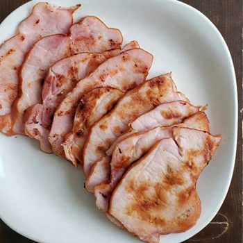 Slices of back bacon on white plate