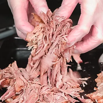 Holding pulled pork with both hands