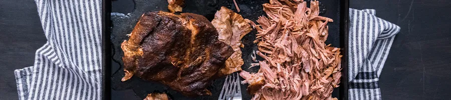 Reheated pulled pork on a black tray