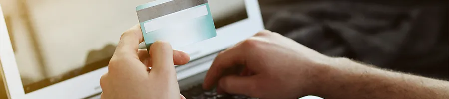 Shopping online on a laptop while holding credit card
