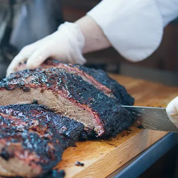 Butcher trimming franklin brisket