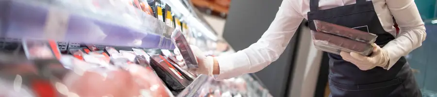 Supermarket worker organizing packed meats