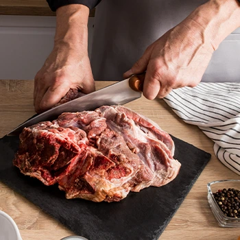 hand view of a person slicing meat