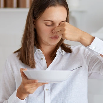 woman smelling spoiled food