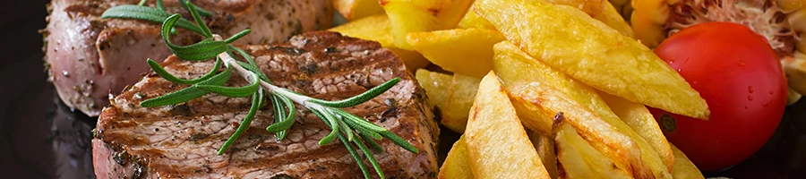 Close up image o sirloin steak with side dishes and tomatoes