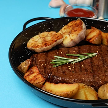 Sirloin steak on pan with spices blue background