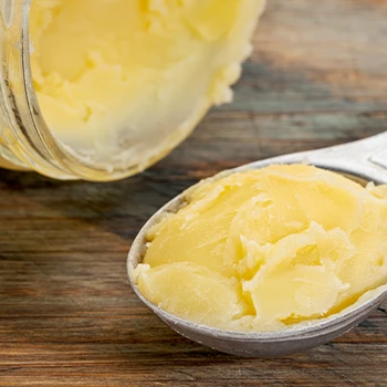 Scoop of Ghee close up image with jar