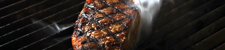 Close up image of a meat being grilled on top of an infrared grill