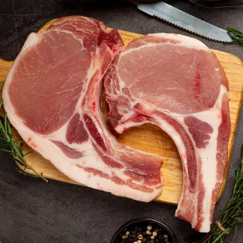 Top view of pork chops on wooden board