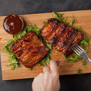 Cutting ribs in half using a knife and fork