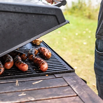 Opening the lid to check the smoked meats