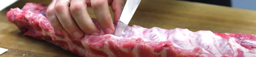 Using a knife to cut the silverskin out of the ribs
