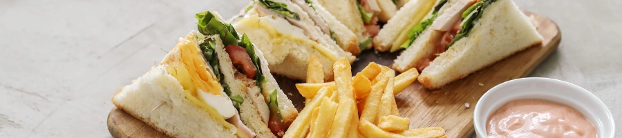 Sandwiches and french fries on a cutting board