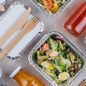 Healthy meals on a container with cutleries