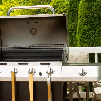 Showing a gas grill with a wide cooking area in the backyard