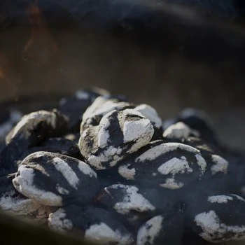 Charcoal briquettes turning into ash close up image