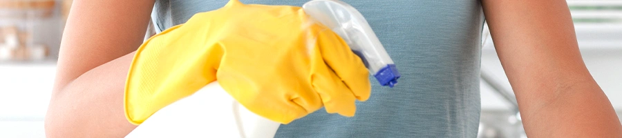 Woman holding a spray bottle with protective gloves