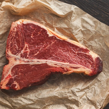 Top view of a raw t bone steak on a craft paper