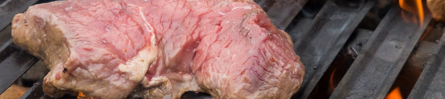 Close up image of a raw beef on a grill