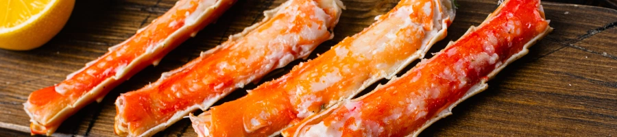 Crab legs lined up on a wooden board