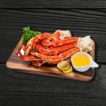 Served grilled crabs on a wooden board with lemon slices