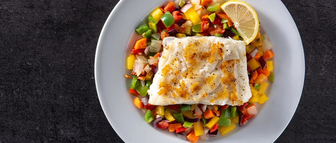 Top view of grilled Cod on plate with vegetables