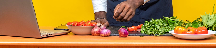 A person in the kitchen preparing his meal while watching tutorial