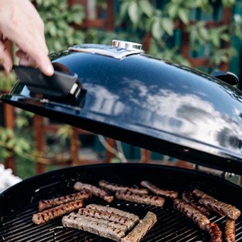 Closing lid of a bbq grill with meats inside