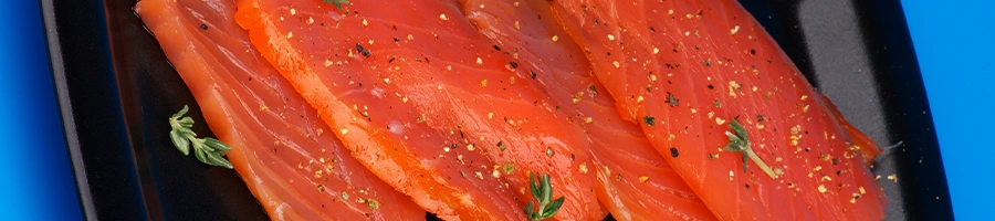 Top view of smoked salmon on black plate