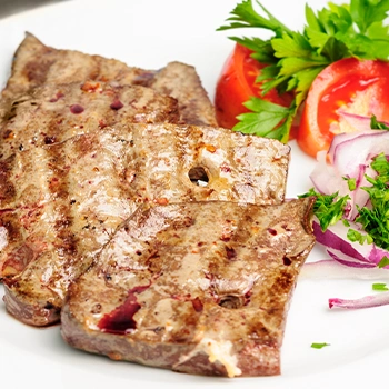 Beef liver with vegetables on plate