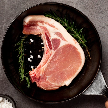 Top view of pink pork chop on pan