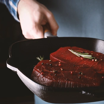 A pan with uncooked steak