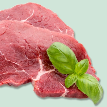 Raw beef on green background