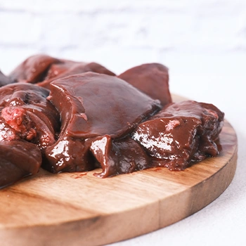 Raw liver on wooden circular board