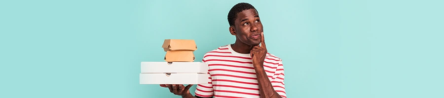 man holding up food package while contemplating