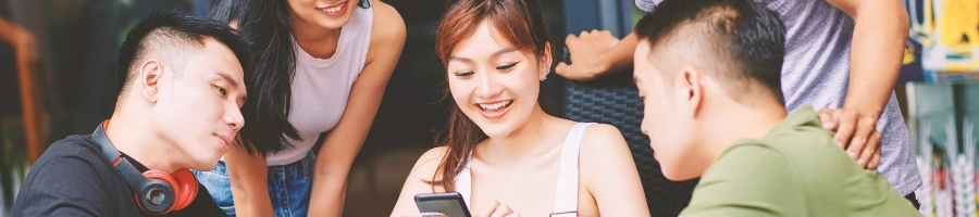 A group of people looking at a phone