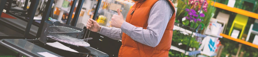 A man looking at grills in a store