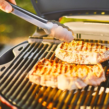 Steak being cooked on a grill outside